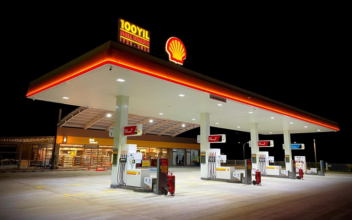 Gece aydınlatılmış Shell akaryakıt istasyonu, kanopisi ve pompa adaları